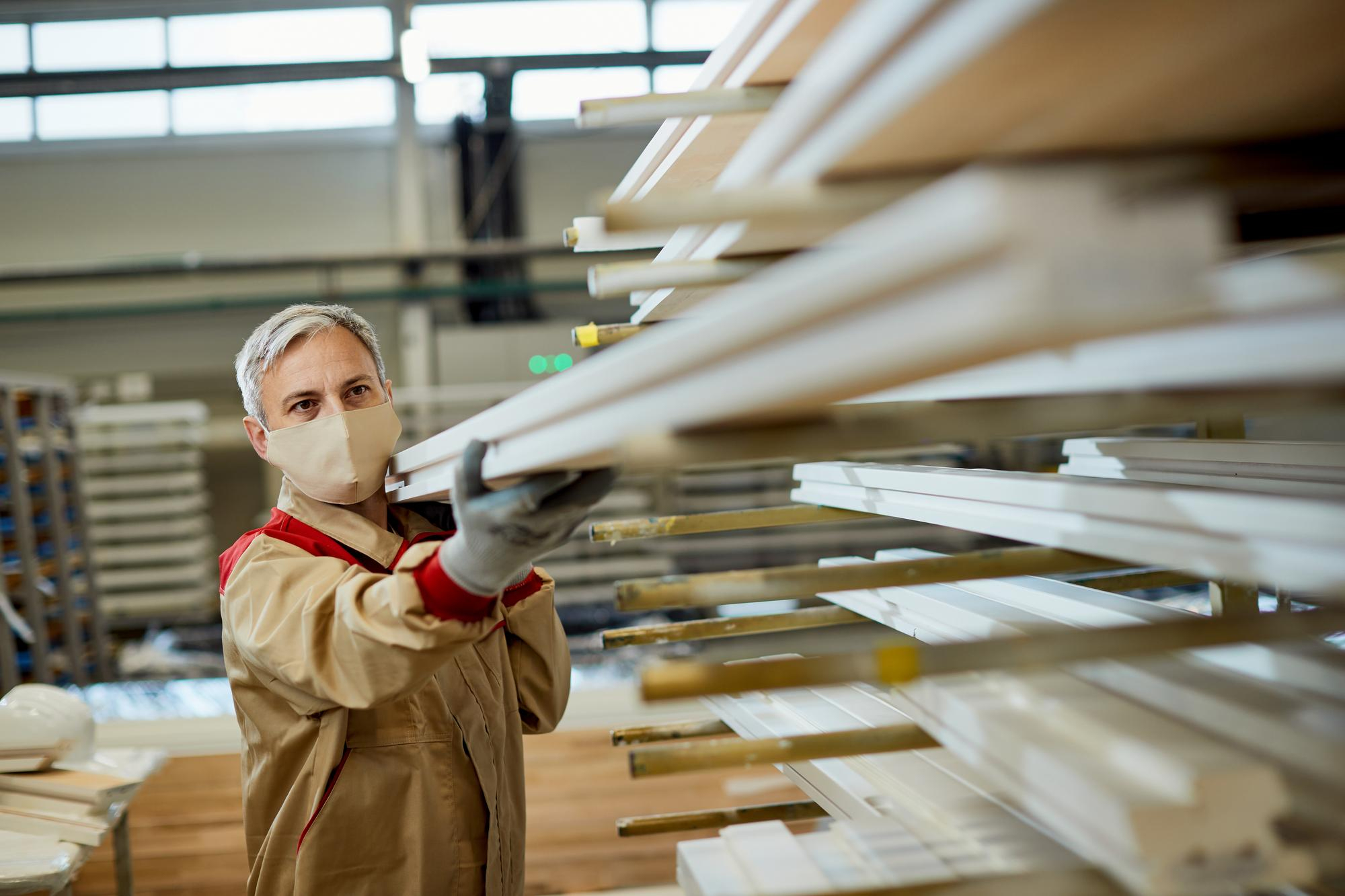 A worker placing finished cladding boards on a timber rack