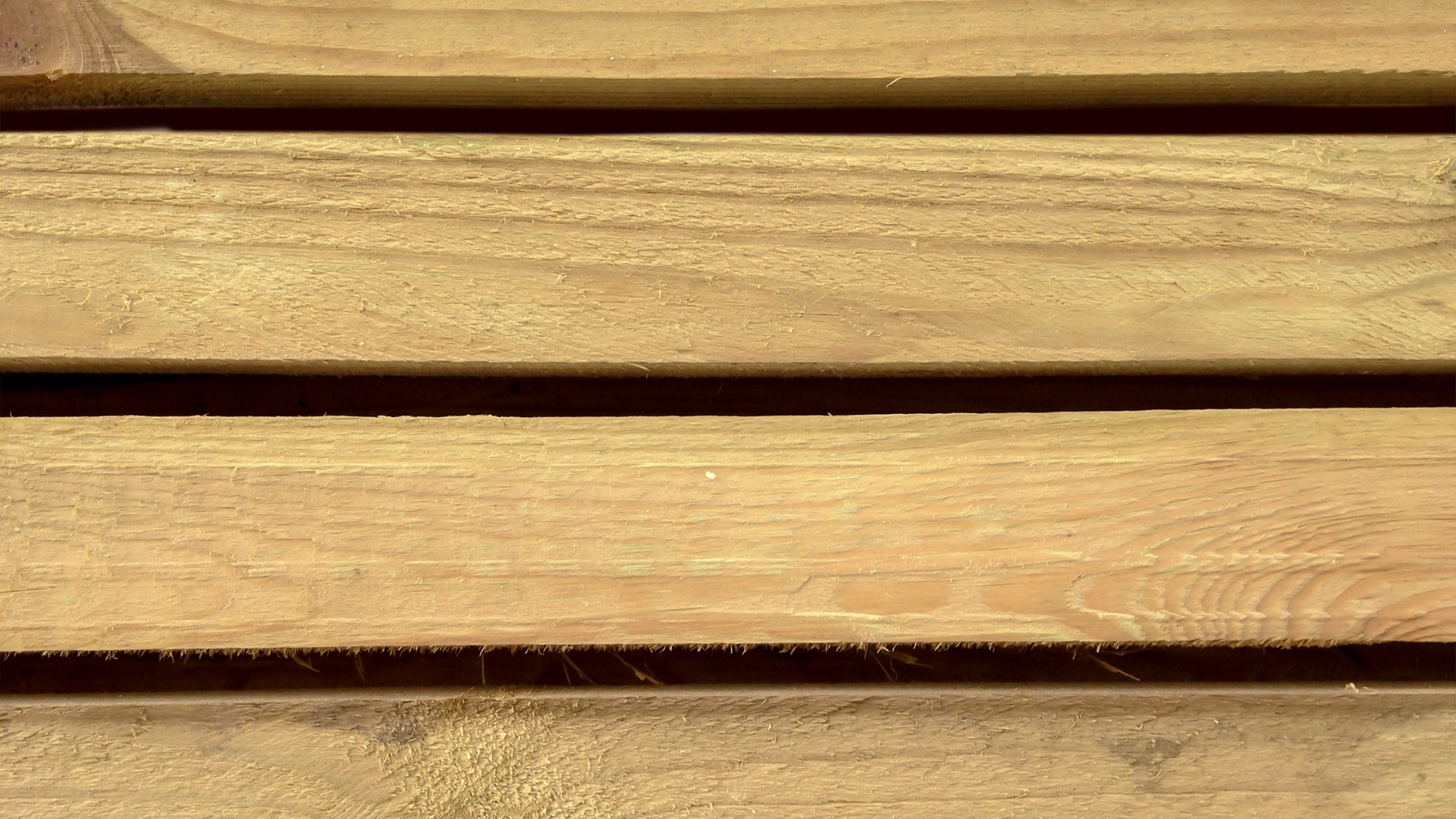 Close up of yellowed timber beams stacked on top of each other