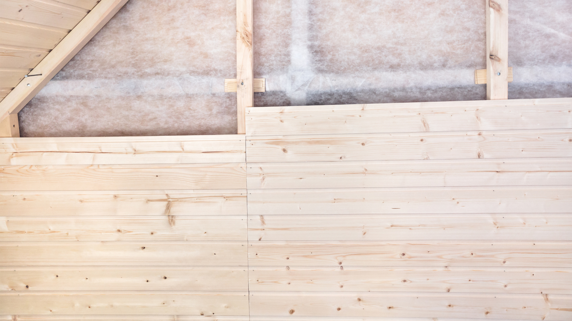 Cladding on interior of shed being installed on a timber frame